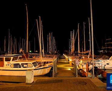 Mikołajki nocą – port jachtowy pełen świateł i refleksów w wodzie